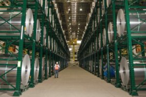 A worker standing next to Dexco Coil Rack Storage Systems