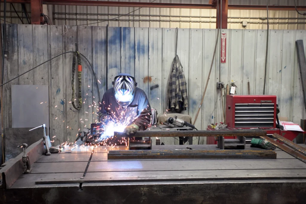 Dexco worker welding a piece of metal in a workshop