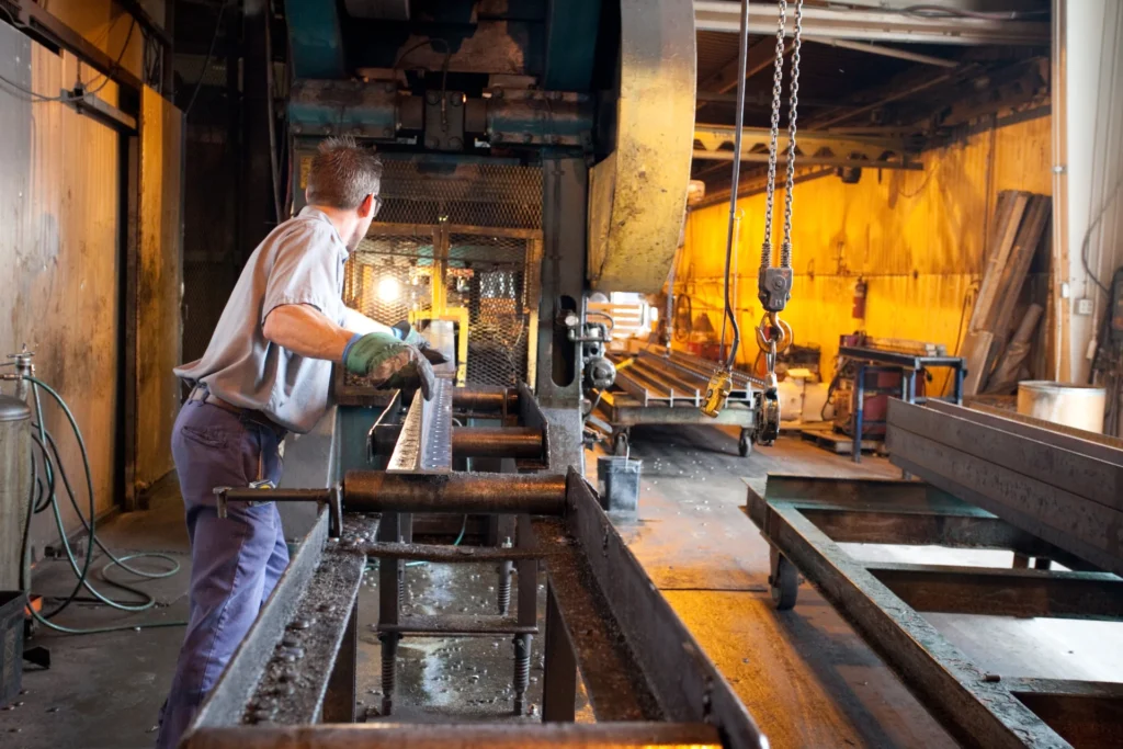 Dexco machine operator putting a piece of metal into a machine
