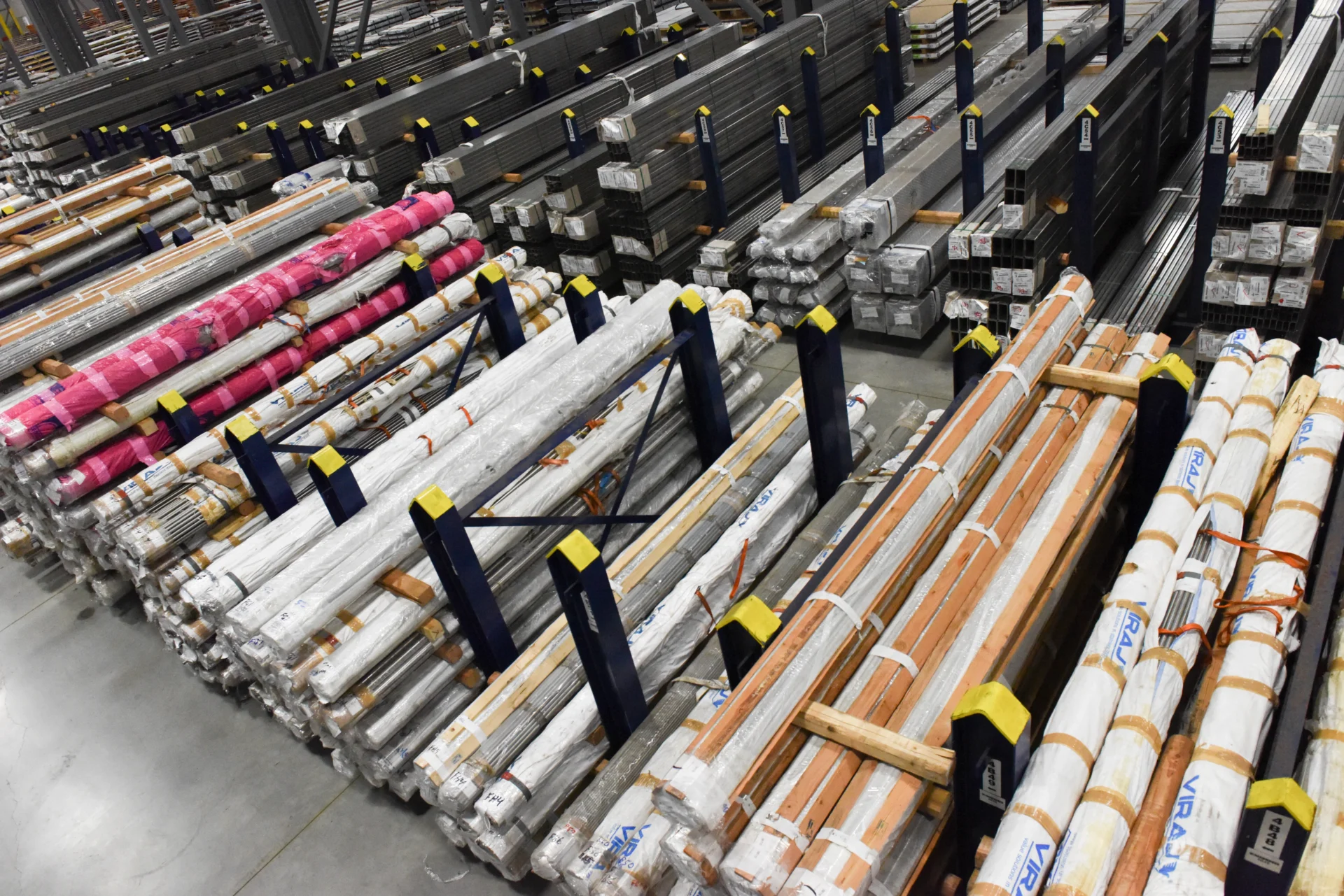 Custom Dexco floor stanchion racks storing various sizes of steel bar and tube at a metals distribution facility