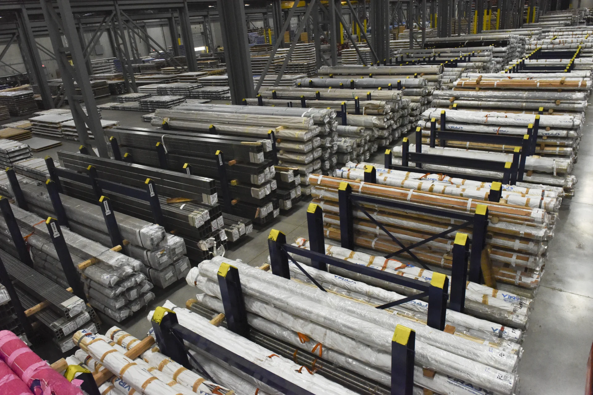 Dexco combination cantilever and floor racks storing mixed steel materials at a metals distribution facility