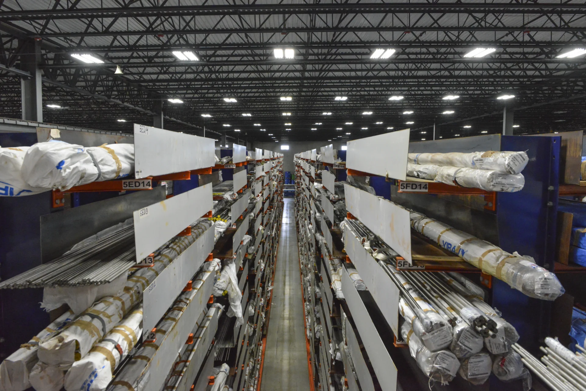 Dexco cantilever racks storing various sizes of steel bar and tube at a metals distribution facility